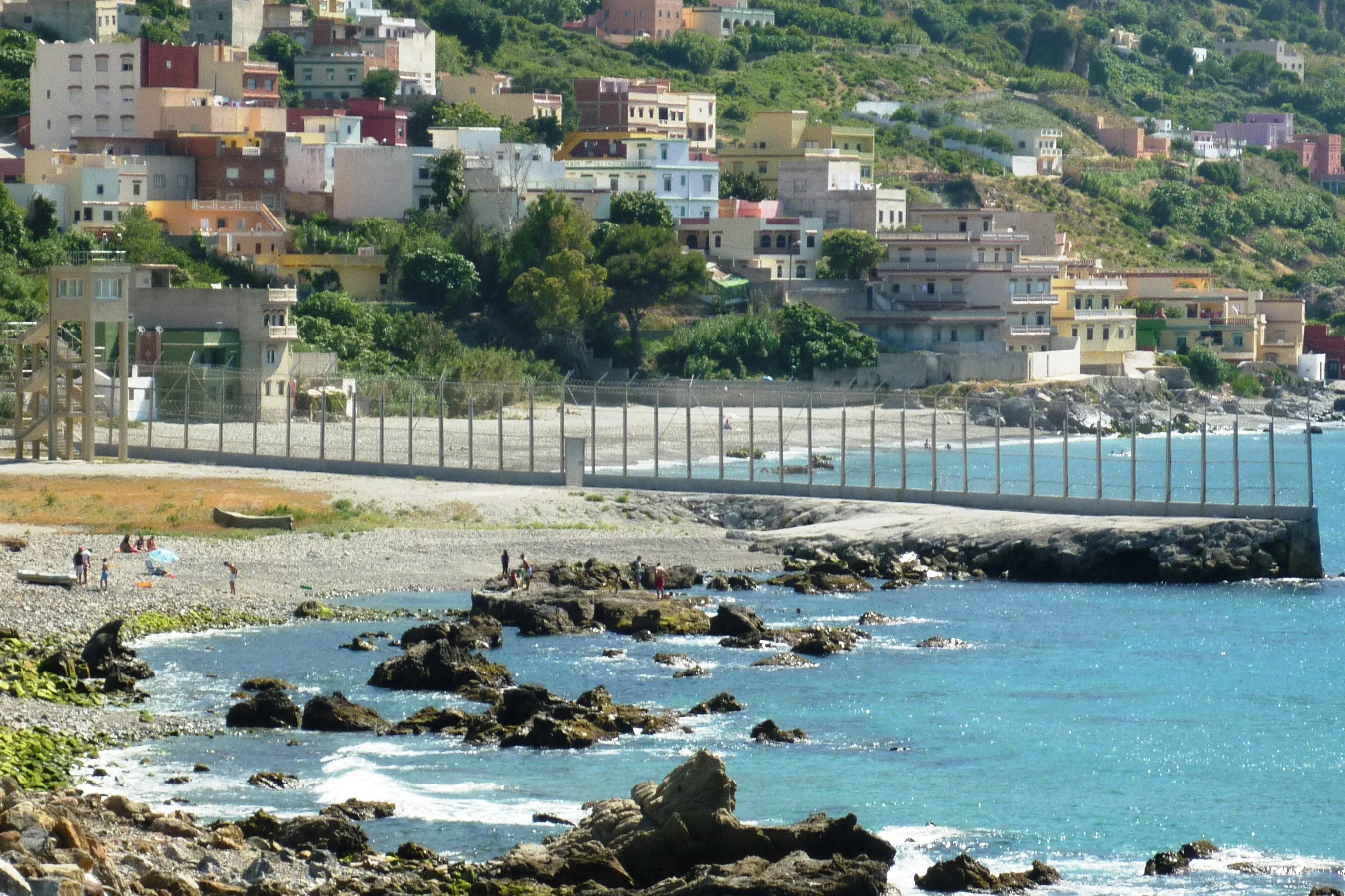 La recinzione di confine di Ceuta, con l'abitato costiero sullo sfondo